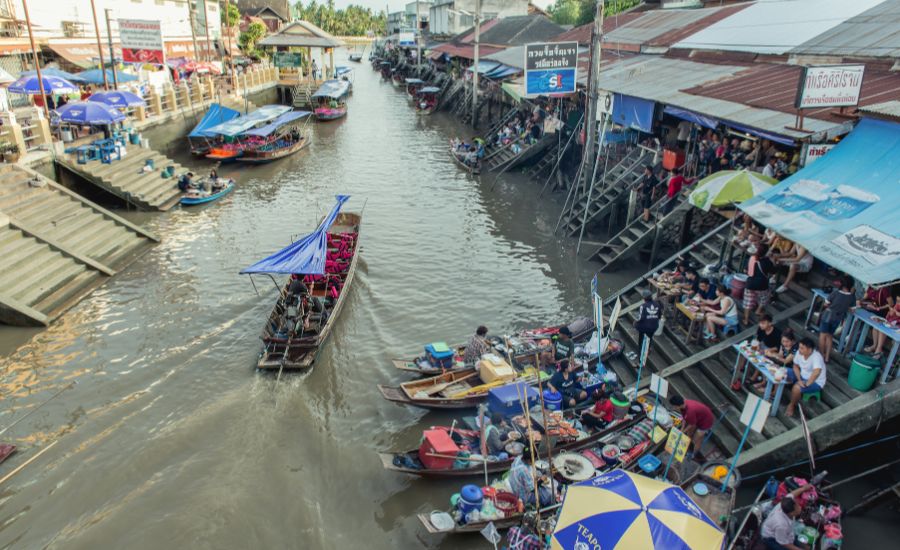 A lively view of boats navigating the canal at Amphawa Floating Market in Samut Songkhram.