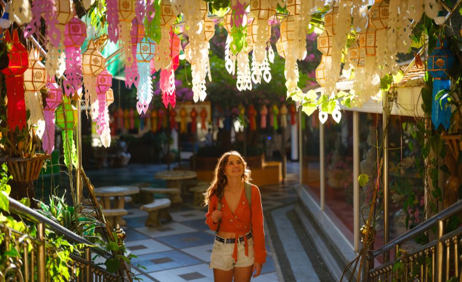 A traveller enjoying the festive atmosphere under colourful Lanna lanterns in Chiang Mai
